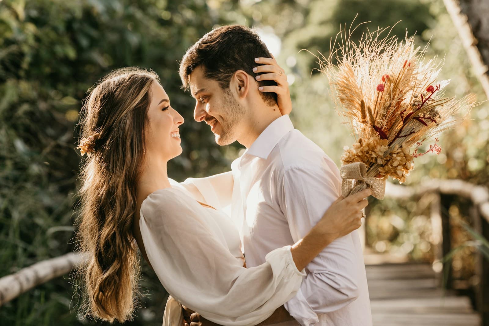 A couple smiling together outdoors with a bouquet. Temporary editorial photograph.