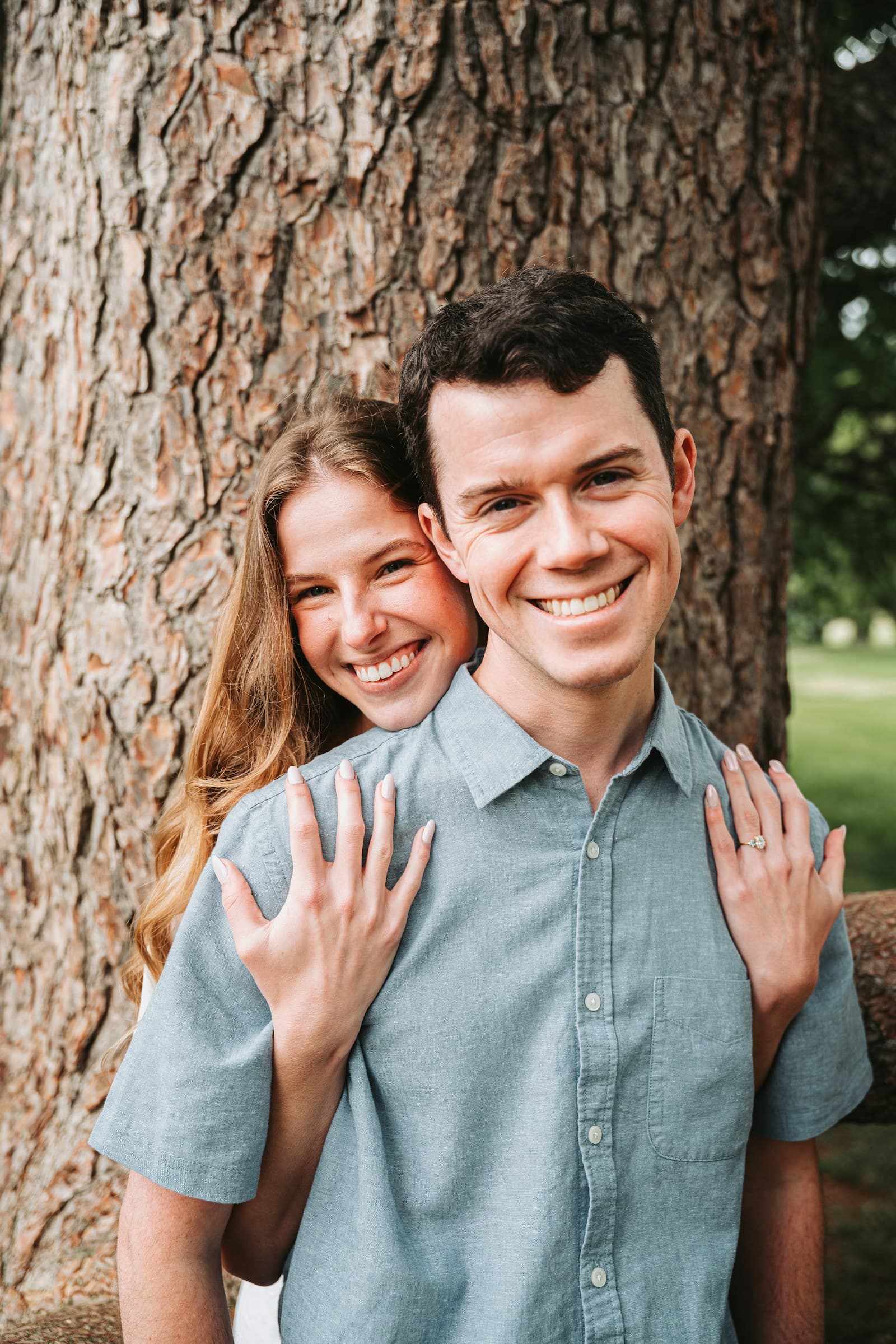 An engaged couple together beside a tree. Temporary editorial photograph.