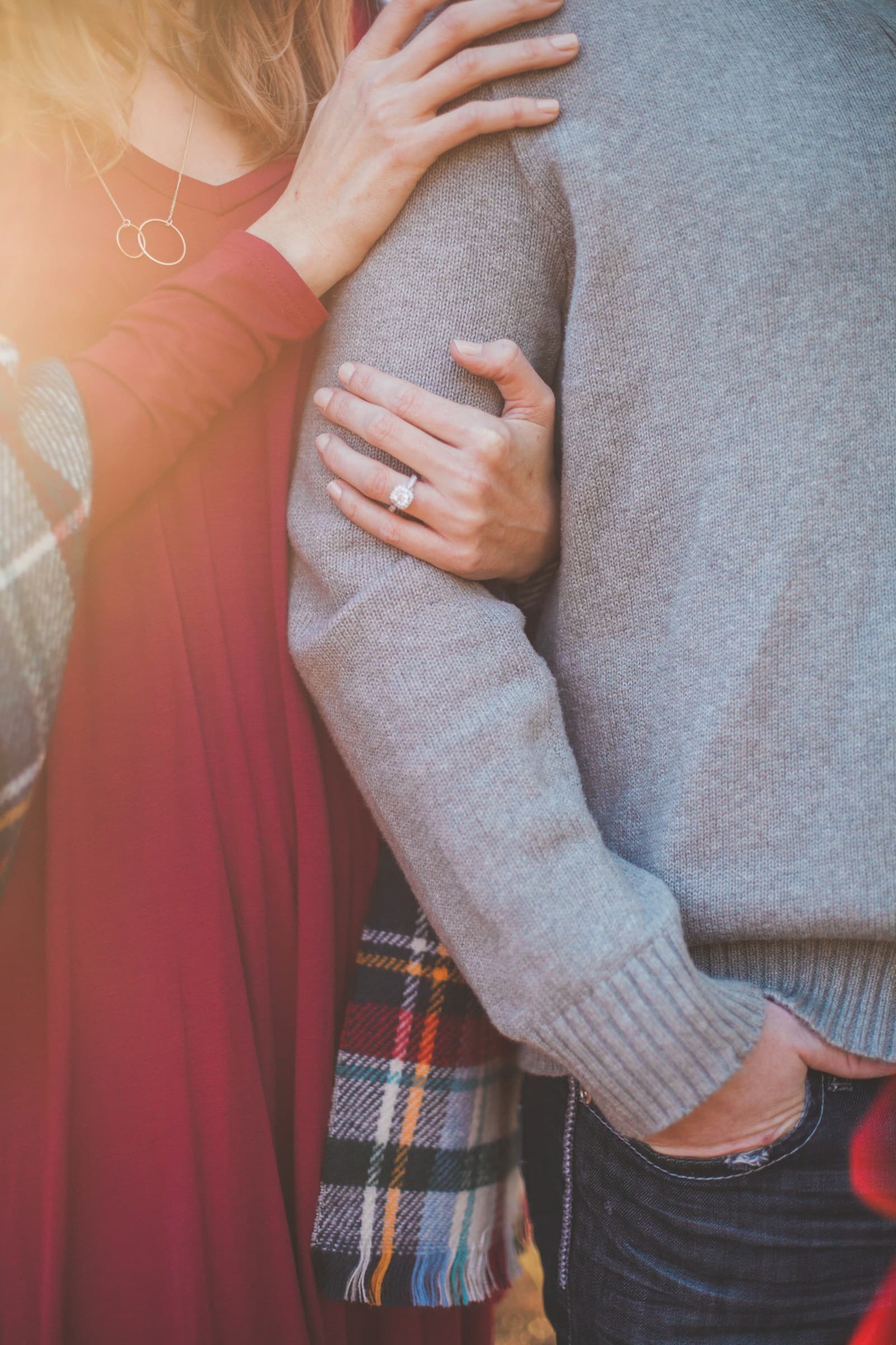 A close-up of a couple embracing in soft sunlight. Temporary editorial photograph.