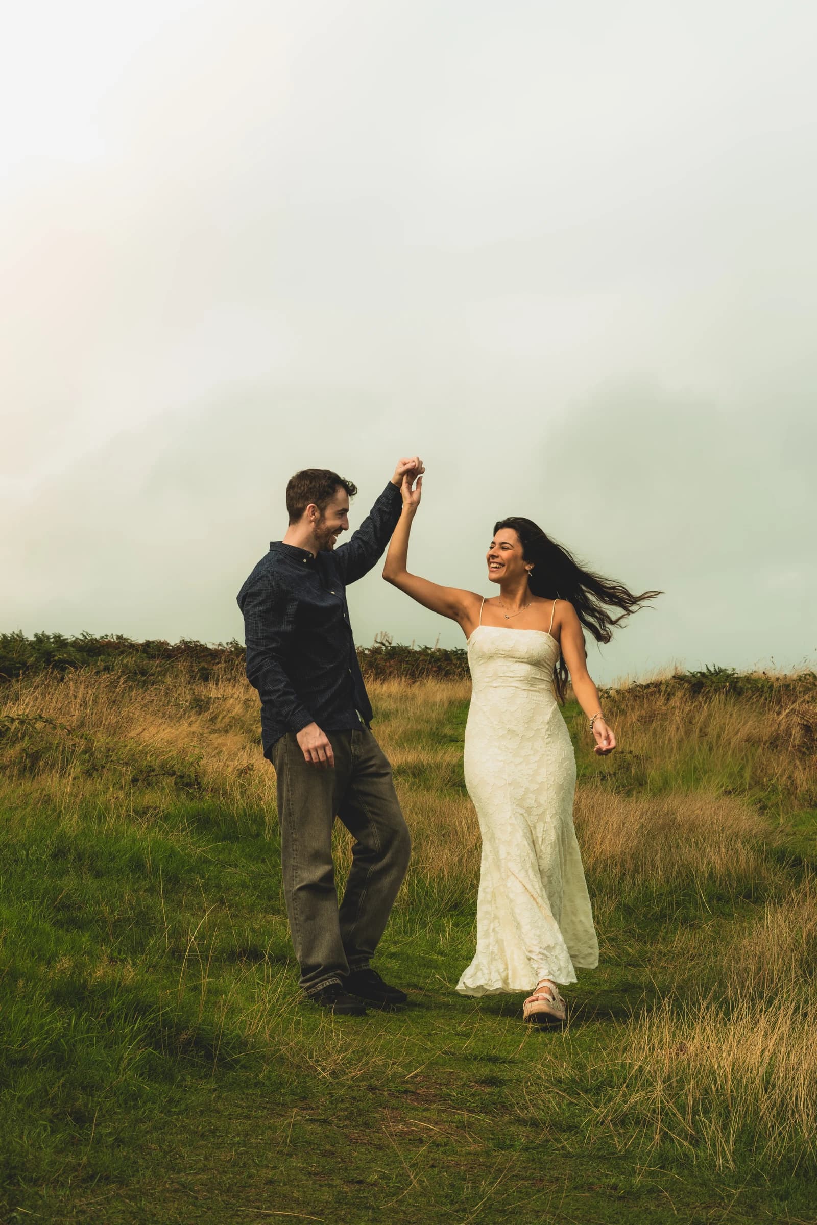 Alice and Jamie dancing together in a grassy field.